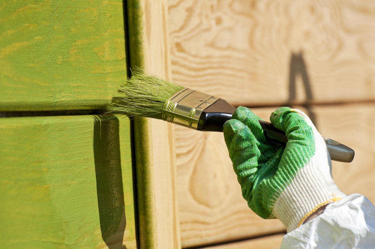 mano de pintor pinta madera en verde