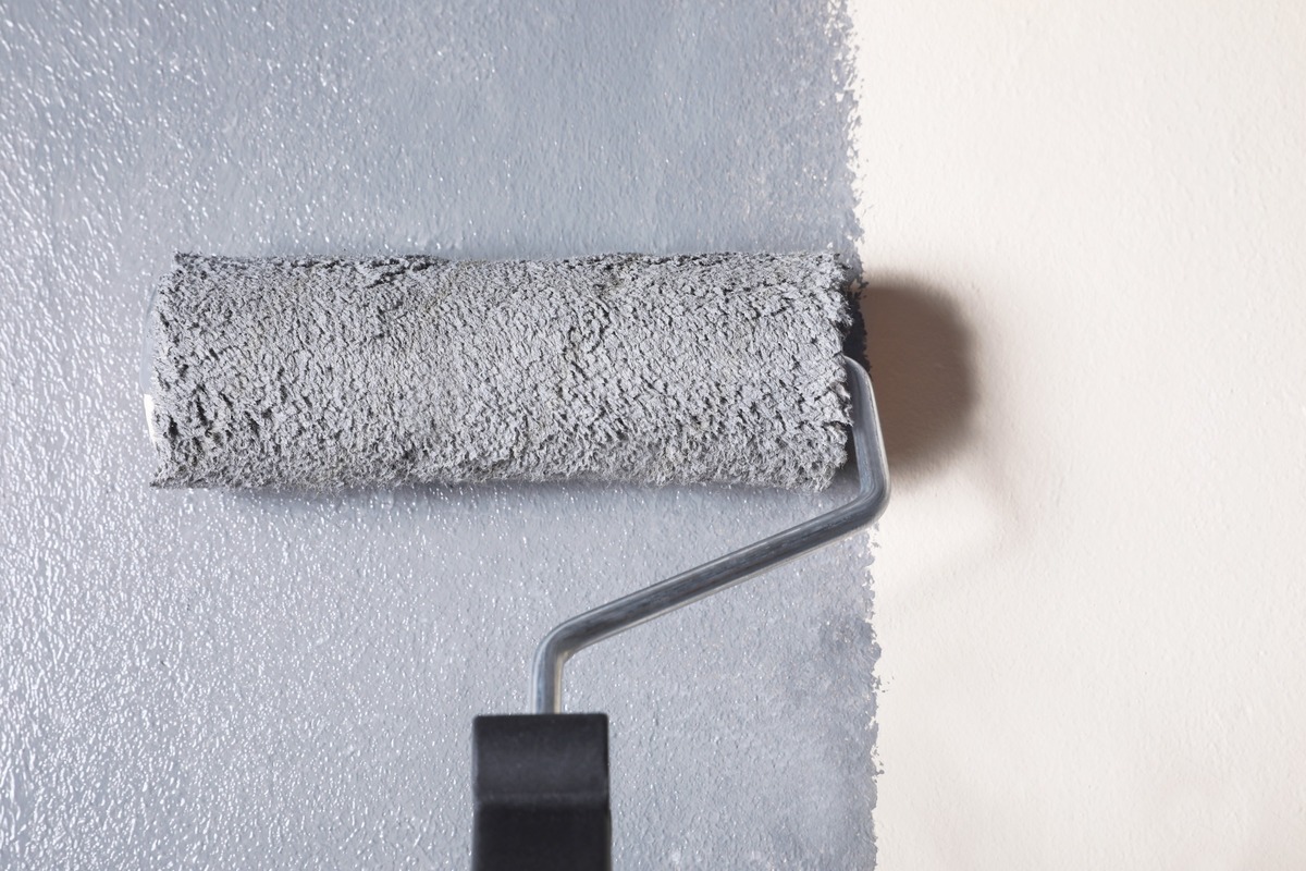 recorte rodillo pintando en gris sobre pared